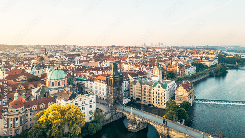 Fototapeta premium Charles Bridge stretches across the Vltava River, connecting the Old Town and Lesser Town. The Old Town Bridge Tower stands majestically, surrounded by stunning architecture and vibrant history.