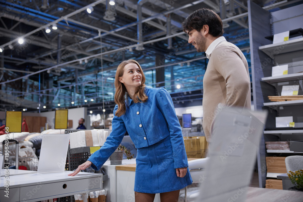 Obraz premium Loving couple is exploring and shopping for stylish office furniture in a modern retail store