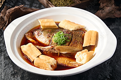 фотографія Wild bighead carp head braised in Beijing-style sauce with large fried dough sti