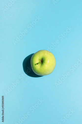 Green apple on a blue background creates a fresh contrast