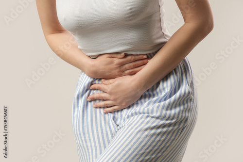 Woman having a painful stomach ache, chronic gastritis or abdomen bloating, upset stomach, menstrual cramps, urinary tract infection symptoms