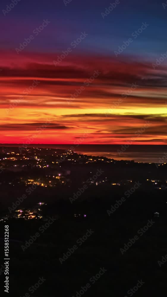 Sunset to twilight hyperlapse over Bali coastline with red and orange sky, aerial vertical shot Sunset to twilight hyperlapse over Bali coastline with red and orange sky, aerial vertical shot