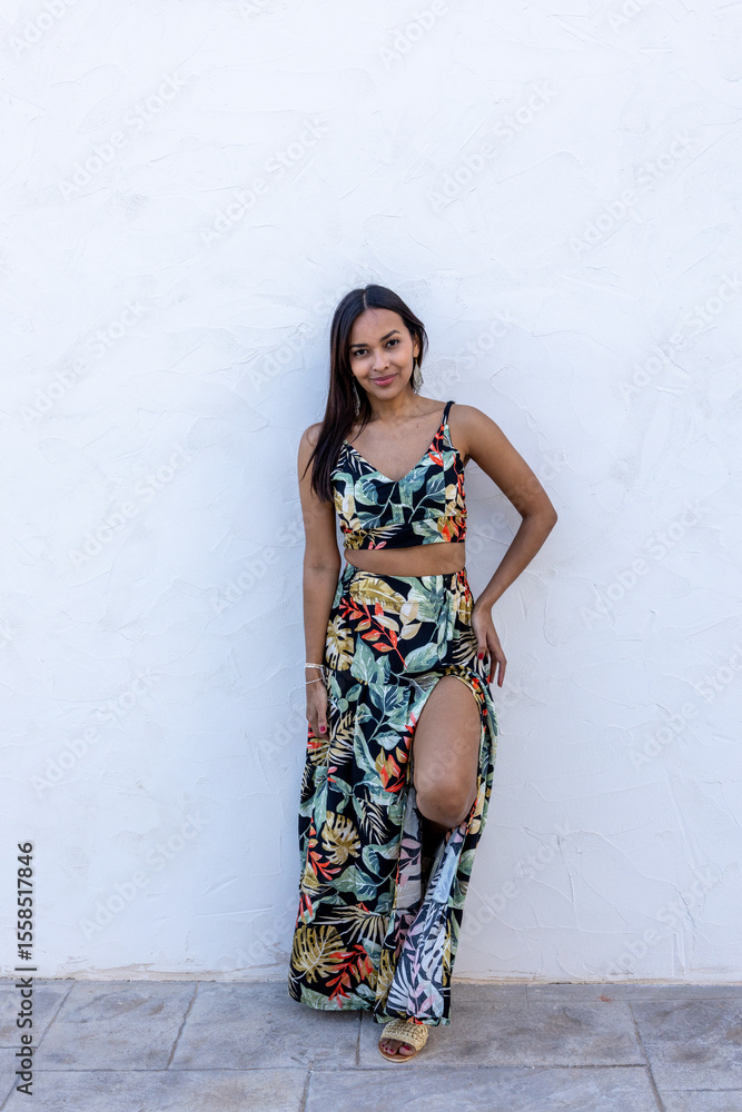Fototapeta premium Brunette woman on a white background wearing a summer dress.