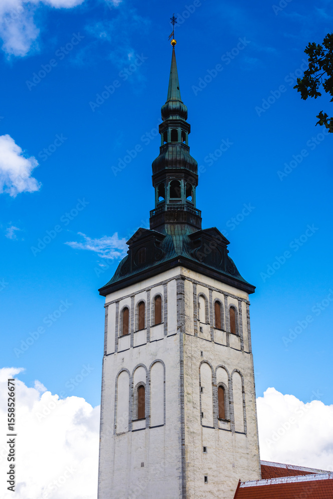 Obraz premium St. Nicholas Church (Niguliste kirik) tower in Tallinn Old Town, Estonia, featuring historic white stone walls, Gothic architecture and tall green copper spire.