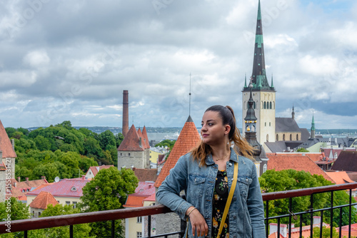 Fotografi Portrait of a woman standing at Patkuli viewing platform in Tallinn, Estonia, with scenic view of medieval towers, St