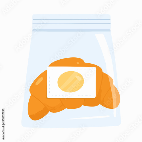 A croissant is sealed in a clear plastic bag with a white label bearing a yellow circle