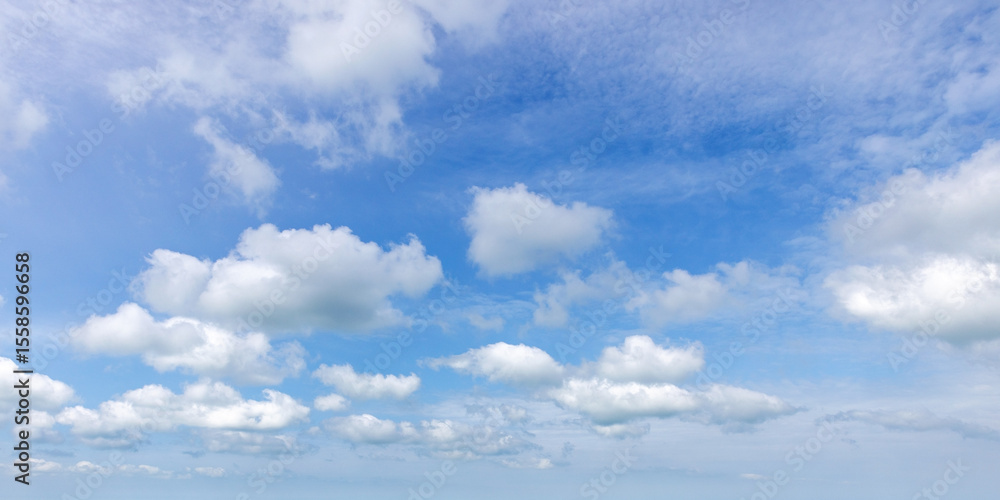 Panoramic photo of clear blue sky adorned with pristine, fluffy white clouds Panoramic photo of clear blue sky adorned with pristine, fluffy white clouds