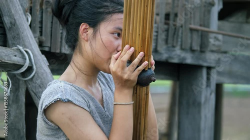 Young Asian woman playing the Khaen, a traditional musical instrument of the Isan region of Thailand. video 4K