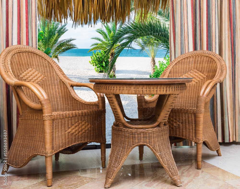 Fototapeta premium Wicker chair and table are in front of a window