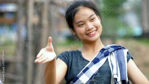 Smiling, beautiful rural young Asian woman dancing, having fun at cultural event in the village at Thailand, moving slowly, video 4K