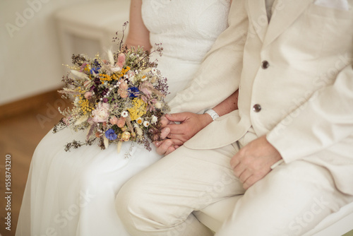 Brautpaar mit Eheringen und Brautstrauss aus Trockenblumen im Standesamt