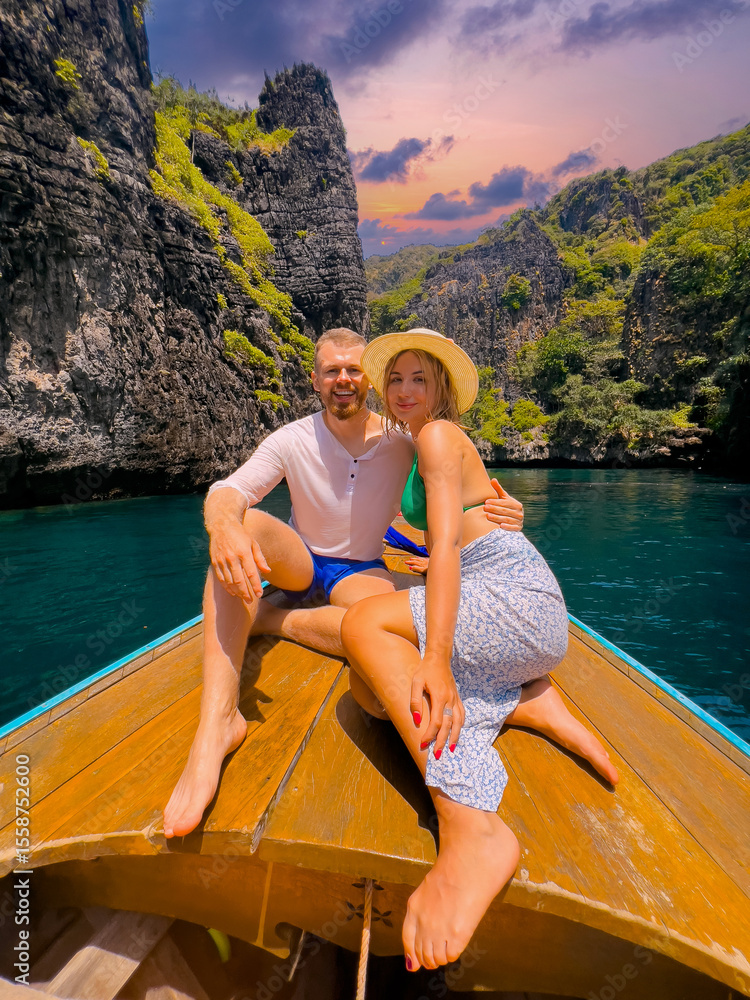 Obraz premium Lover Couple enjoying scenic boat ride in maya bay, Thailand's stunning island paradise