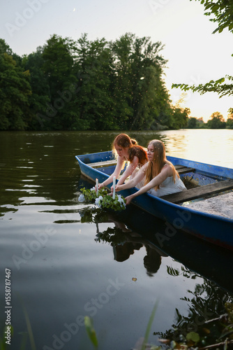 Canvas Print Girls float flower wreaths with candles on a lake during a traditional Slavic midsummer ritual