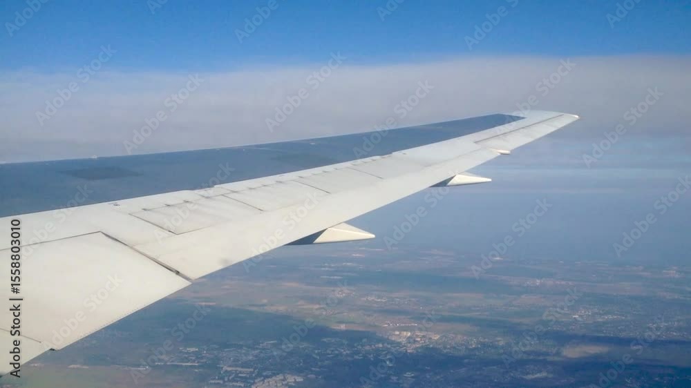 View of landing from airplane window. Wing of the plane, blue sky and clouds. Travel concept. View of landing from airplane window. Wing of the plane, blue sky and clouds. Travel concept.