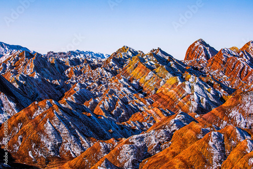 Amazing scenery of Rainbow mountain and blue sky background in sunset. Zhangye Danxia National Geopark, Gansu, China. Colorful landscape, rainbow hills, unusual colored rocks, sandstone erosion