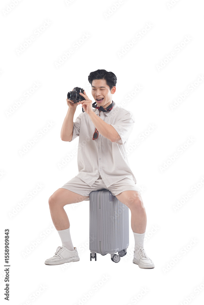 Fototapeta premium Man With Camera: A cheerful man wearing casual attire sits atop his luggage with a camera in hand, ready to capture memorable moments on his trip. Reflecting the spirit of exploration and discovery