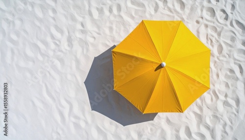  Top view of a bright yellow beach umbrella casting a soft circular