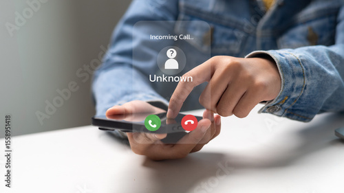 Fotografi A person receiving an incoming call from an unknown number decides whether to accept or reject the suspicious call, representing a spam call and phone scam alert