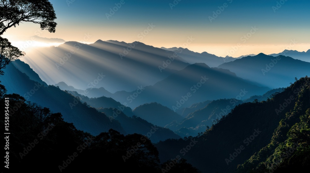 Obraz premium Sunlight shining through mountain ranges creating a beautiful landscape scene