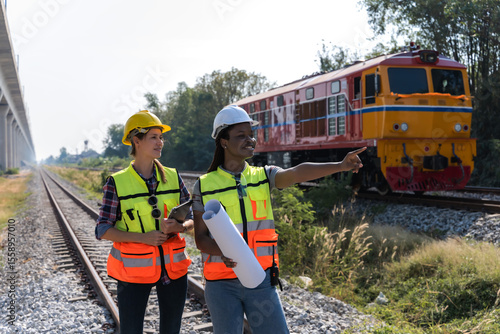 Obraz na płótnie Diversity female locomotive engineers working outdoor at train track, rail techn