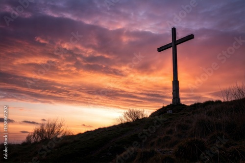 Cross at sunset. Wooden cross on the hill. Cross of Jesus Christ. Christian symbol. Easter concept. He died for us. 