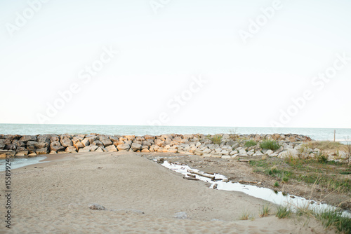 Rock wall and stream meet sandy shore at Rosewood Beach, Illinois