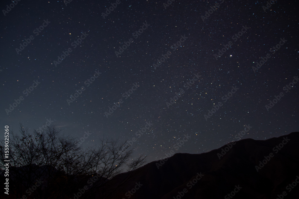 埼玉県秩父市の冬の夜、澄んだ空に広がる星空と山の稜線、木々のシルエットが織りなす静寂で幻想的な風景。自然や天体観測、癒しのイメージに最適な冬の夜空の写真素材です。 埼玉県秩父市の冬の夜、澄んだ空に広がる星空と山の稜線、木々のシルエットが織りなす静寂で幻想的な風景。自然や天体観測、癒しのイメージに最適な冬の夜空の写真素材です。