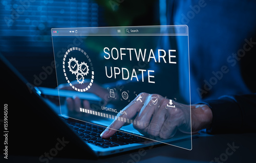 Obraz na płótnie Software Update and System Upgrade Concept. Person holding phone while using laptop with software update progress interface and security, technology maintenance, application upgrades, system security.