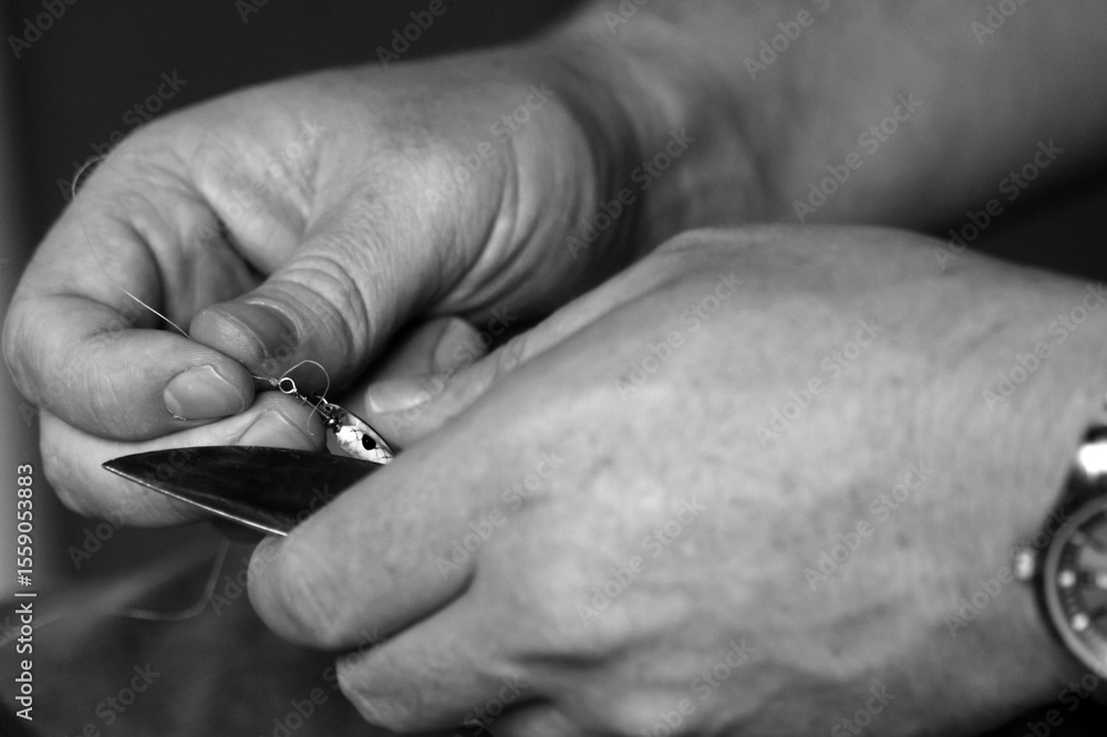 Obraz premium hands tying lure