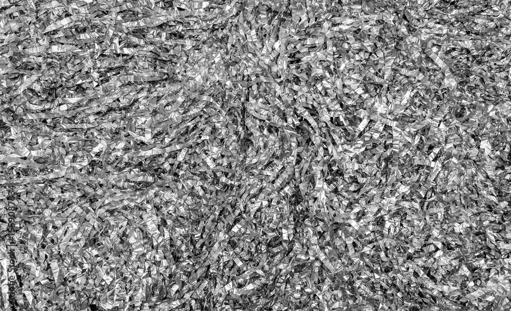 Festive shiny silver tinsel background. The texture of sliced crumpled foil. Festive shiny silver tinsel background. The texture of sliced crumpled foil.