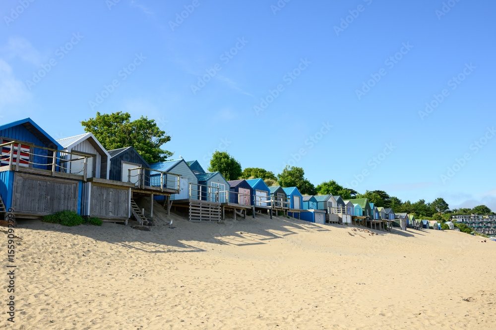 Obraz premium Traditional Beach Huts Lining the Shore in Abersoch, Wales