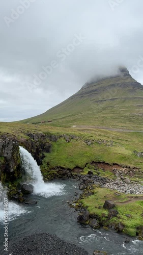 Cloud-covered Kirkjufell with Kirkjufellsfoss waterfall in the foreground. A dramatic and iconic view from Iceland’s Snæfellsnes Peninsula, beloved by photographers and travelers.