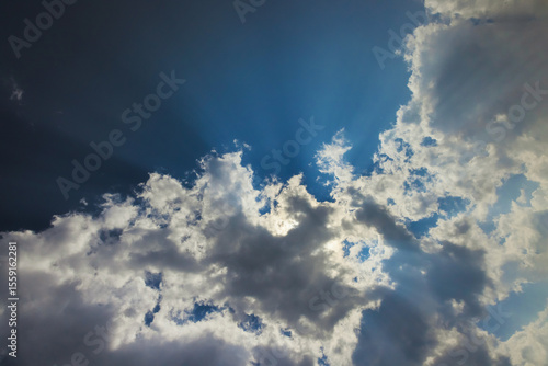 Fototapeta Naklejka Na Ścianę i Meble -  Soft clouds float in fluffy sky as sunlight streams through, creating serene atmosphere on sunny afternoon