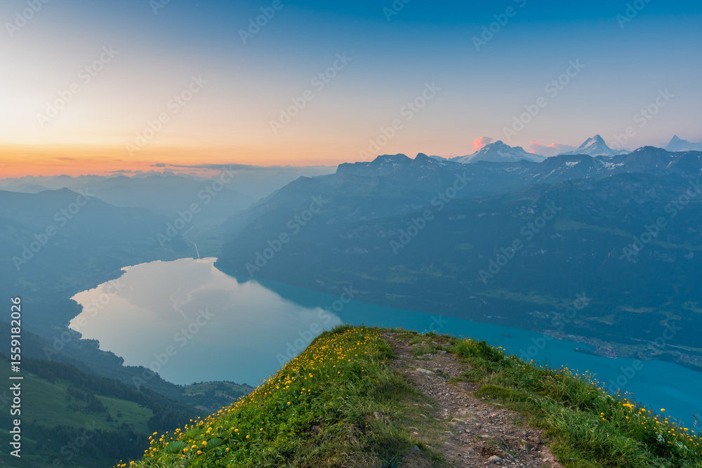 Fototapeta premium Sunrise on Augstmatthorn, painting the sky in gold above Brienzersee. A peaceful moment above the clouds, where silence meets breathtaking alpine beauty.