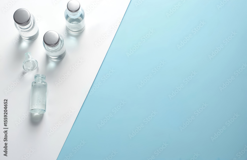 Medical bottles, ampoules vaccines displayed on white blue background. Healthcare concept, science research, laboratory experiment, vaccination, treatment, cure, medicine, health. Medical bottles, ampoules vaccines displayed on white blue background. Healthcare concept, science research, laboratory experiment, vaccination, treatment, cure, medicine, health.