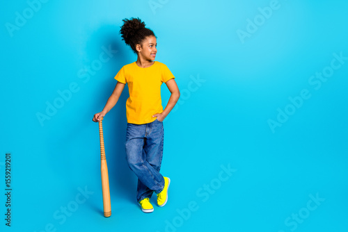 Photography Stylish young girl in casual outfit posing with a baseball bat against a bright