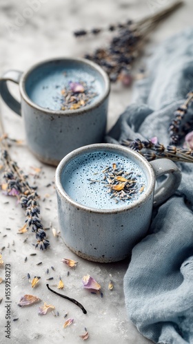 Two Cups of Lavender Blue Latte With Dried Flowers and a Spoon on a Marble Su...