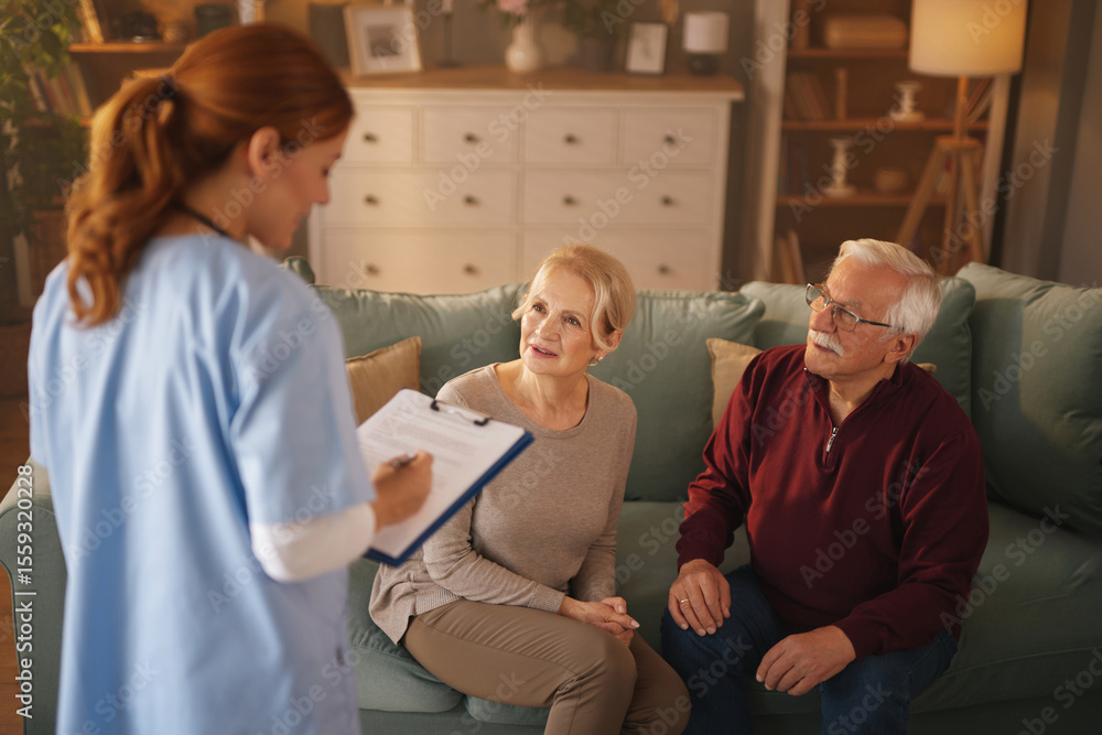 Obraz premium In a brightly lit living room, a home nurse with clipboard discusses a care plan with an elderly couple sitting on a sofa. The senior woman and man listen attentively.