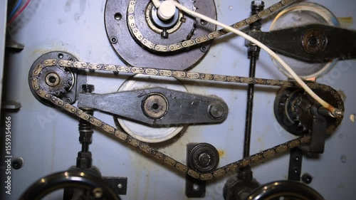 A mechanical chain drive system that drives gears and lever joints during operation of an industrial machine in close-up