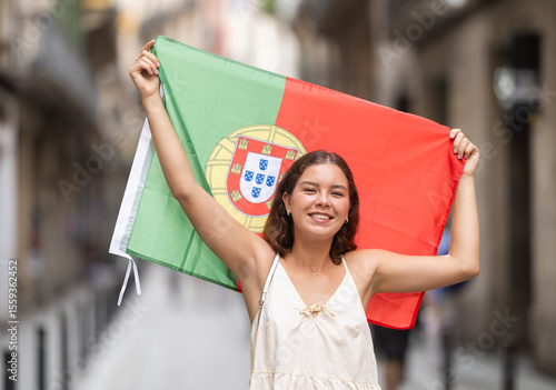 Young woman in summer dress with Portuguese flag on city street