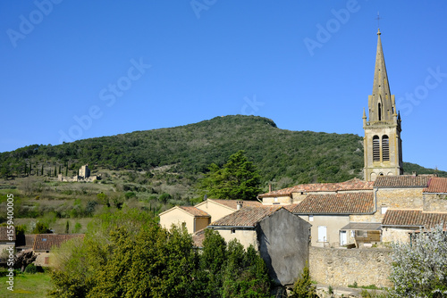 Landscape view of Saint-Sauvers-deCruziéres, showing the old church, some roofs and the mountains around
