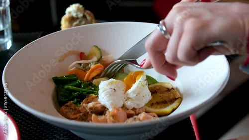 Wallpaper Mural Healthy food at vegan cafe. Green buckwheat with poached egg and avocado. Lifestyle slow video. Modern plate with porridge. Cereal breakfast menu. Woman hand holding. High quality 4k footage Torontodigital.ca