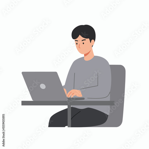 A young man in a gray sweater and dark pants sits at a gray desk typing on a gray laptop