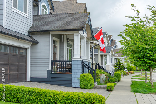 Two story stucco luxury house with Canadian flag in Vancouver, Canada, North America. Day time on June 2025.