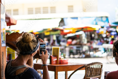 Fényképezés Tourist taking pictures of traditional market in kratie, cambodia