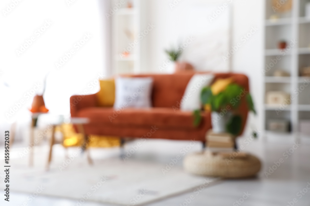 Obraz premium Blurred view of living room with red sofa and tables