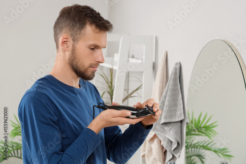 Young man attaching comb to...