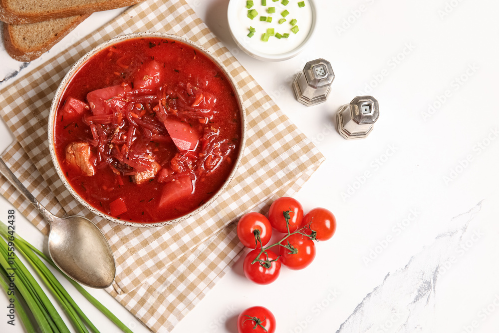 Bowl of tasty Ukrainian borscht with sour cream, green onion and cherry tomatoes on white background Bowl of tasty Ukrainian borscht with sour cream, green onion and cherry tomatoes on white background