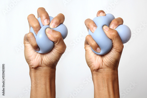 Фотография Two hands with dark skin tones squeeze a light blue, amorphous object, appearing