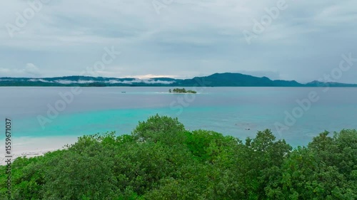 Cinematic aerial view of a beautiful small tropical island. Aerial view of a small island in the middle of a turquoise ocean